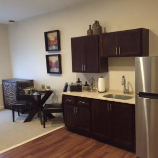 A modern kitchen with dark cabinetry and stainless steel appliances.