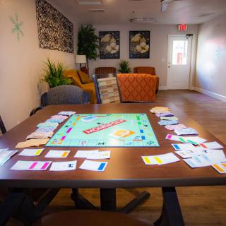 A living room setup with a Monopoly board game ready to play on the table.