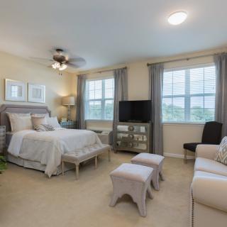 A cozy bedroom with elegant furniture and large windows.