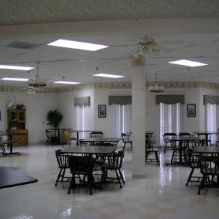 A spacious and well-lit dining area featuring tables and chairs, designed for social gatherings.