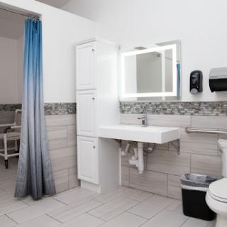 A modern, clean bathroom featuring a sink, toilet, and storage cabinets.