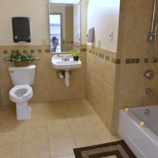 A modern bathroom featuring a toilet, sink, and bathtub, complemented by decorative plants.