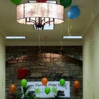 An indoor celebration setup featuring colorful balloons and a festive banner.