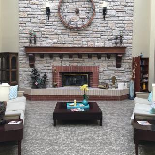 A cozy living room with a stone fireplace and comfortable seating.