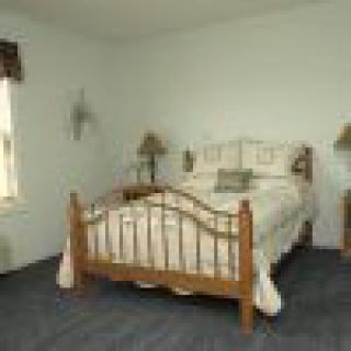 A simple bedroom with a wooden bed and matching bedside tables.