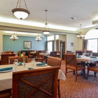 A well-arranged restaurant dining room with tables and chairs set for service.