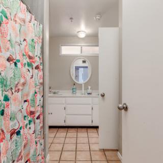 A view of a bright and tidy bathroom featuring a colorful shower curtain and a clean vanity area.
