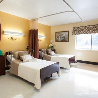 A well-lit hospital room with two beds, designed for patient comfort.