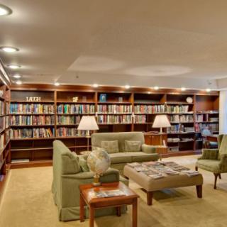A cozy library with bookshelves and comfortable seating.