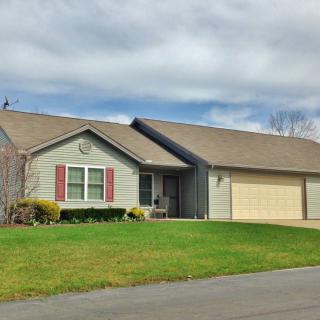 A suburban one-story house with a well-maintained lawn and attached garage.