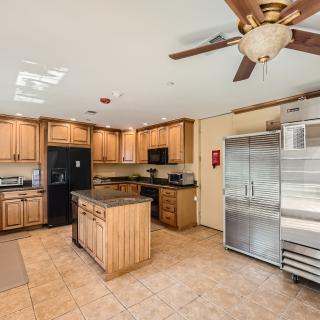 A spacious kitchen with wooden cabinets, a central island, and modern appliances.