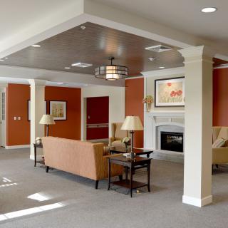 A modern living room featuring a sofa, lamps, and a fireplace with elegant interior design.