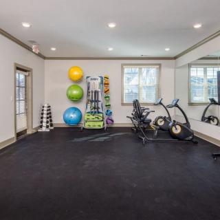 A modern gym with exercise equipment including stationary bikes and colorful exercise balls.