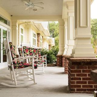 A cozy porch with rocking chairs and classic architecture.