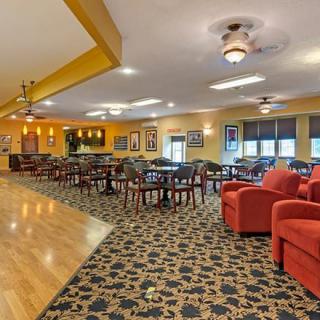 A spacious dining area with a bar, featuring various tables and seating options.