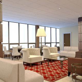 A modern living room with white furniture and a red patterned carpet, featuring large windows that allow natural light to fill the space.