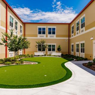 A sunny courtyard in a school building featuring a well-maintained landscape.