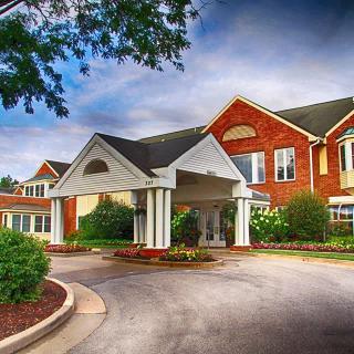 A residential building with a covered entrance and landscaped surroundings.