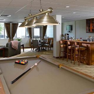 A stylish recreation room features a pool table and bar area, creating an inviting space for socializing and relaxation.