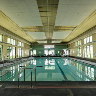 A spacious indoor swimming pool with large windows and ample natural light.