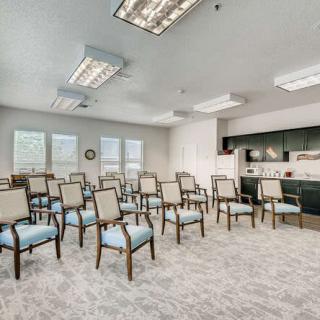 An empty conference room with rows of chairs and fluorescent lighting.