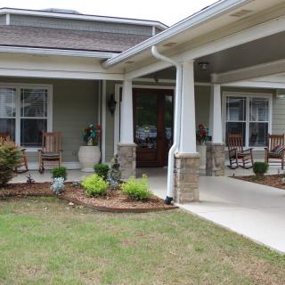 A welcoming house with a spacious porch and well-maintained garden.
