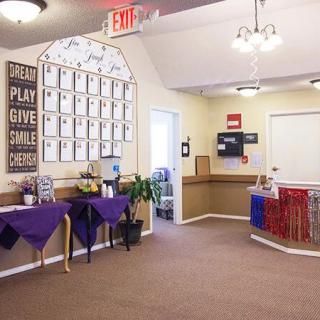 A reception area with certificates on the wall, purple tables, and a welcoming atmosphere.