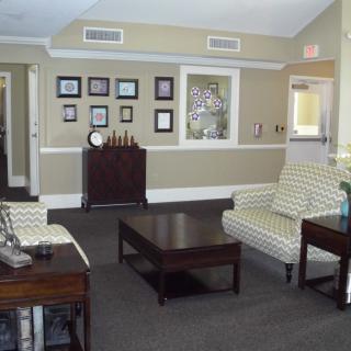 A waiting room with comfortable seating and framed pictures on the wall.
