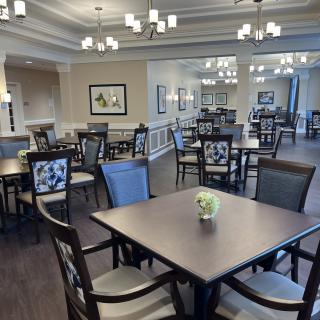 A modern dining room with neatly arranged tables and elegant lighting.