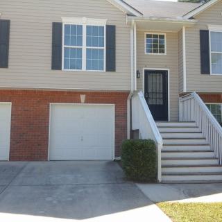 A two-story house with a garage and front stairs leading to the entrance.