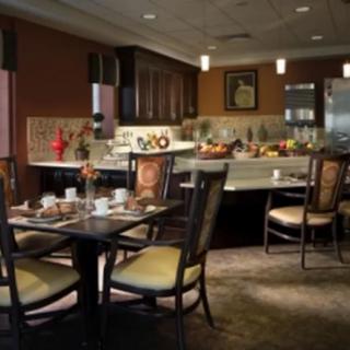 A modern dining and kitchen area featuring elegant furniture and warm lighting.