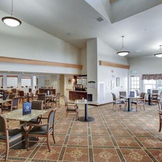 A spacious dining area with tables and chairs, featuring a cozy interior design.