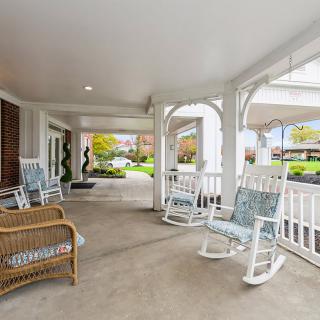 A cozy porch with rocking chairs and wicker seating, perfect for relaxation.
