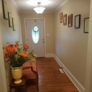 A welcoming hallway with floral decorations and framed artwork.