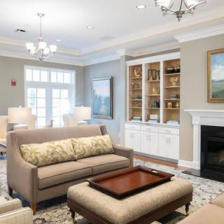 A stylish and cozy living room with elegant furnishings, featuring a sofa, coffee table, fireplace, and bookshelf.