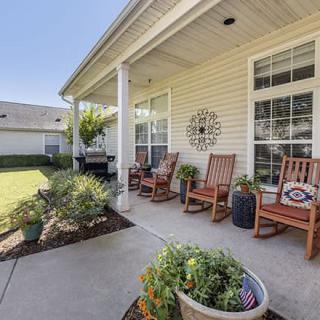 A cozy porch with rocking chairs and plants, perfect for outdoor relaxation.