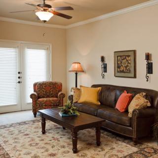 A cozy living room featuring a leather sofa, patterned armchair, and decorative accents.