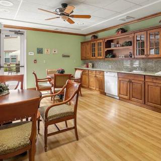 A cozy kitchen and dining area with wooden cabinets and a hardwood floor.