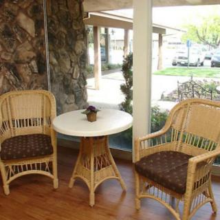 Cozy seating area with rattan chairs and a round table by the window.