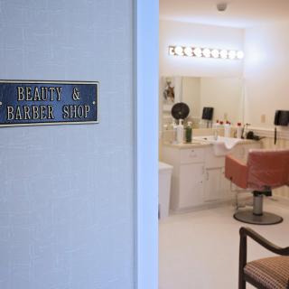 A view into a beauty and barber shop with modern decor and styling stations.