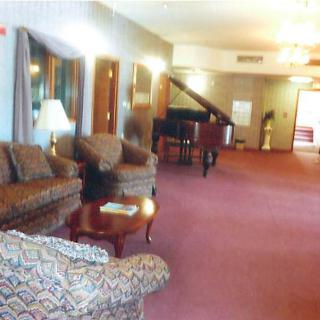 A spacious lounge area with sofas, a piano, and ambient lighting.