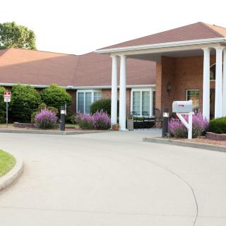 A building with a welcoming entrance, featuring columns and landscaped surroundings.