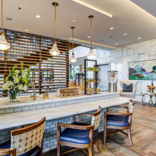 A modern kitchen interior featuring elegant bar stools and stylish lighting.