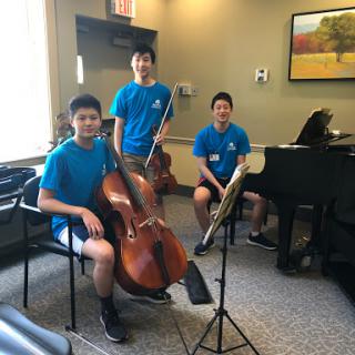Young musicians preparing for a performance with a cello and piano.