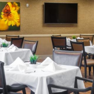 A well-arranged restaurant dining area with white tablecloths and modern decor.
