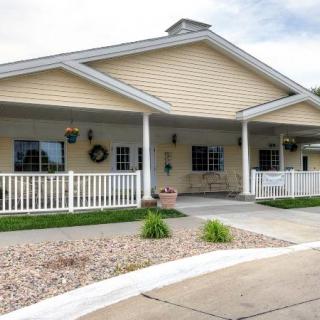 A charming residential building with a front porch and landscaped surroundings.