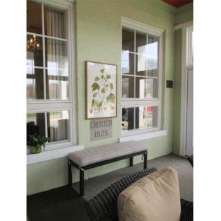 A cozy corner with a cushioned bench and artwork on green walls.
