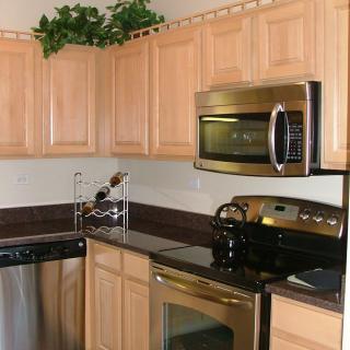 A modern kitchen with stainless steel appliances and wooden cabinets.