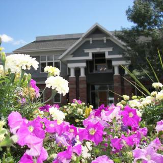 A charming building surrounded by vibrant flowers and greenery.