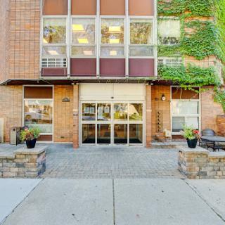 Front view of a modern building with greenery and inviting entrance.
